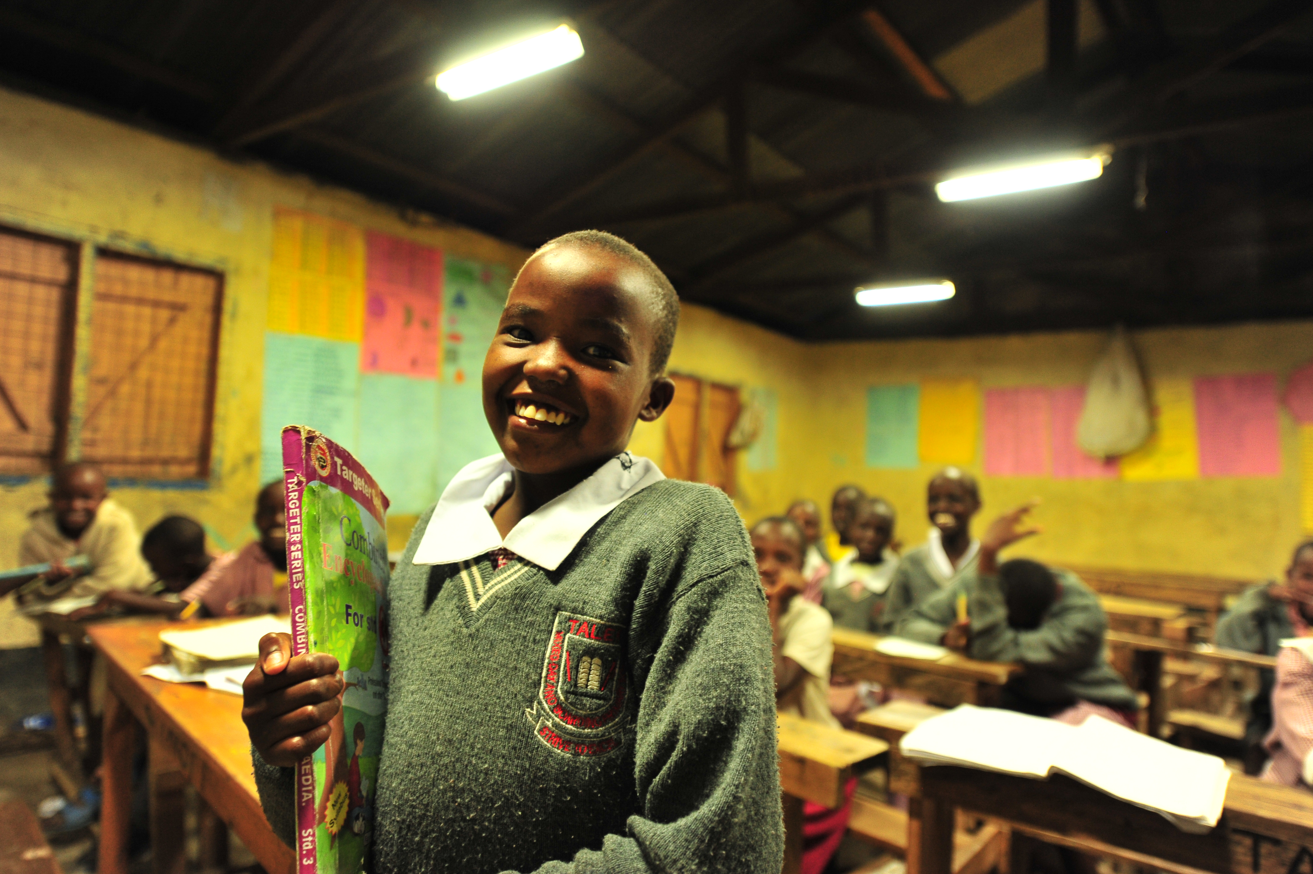 A pupil carries her books to class during night preps at Talek mixed day and boarding primary school. The school relies on its' solar panels for lighting especially after sunset because Talek town is not connected to the national power grid. Residents and business owners in Talek have had to rely on alternative power sources but this is set to change with the Talek Solar Powered Mini Grid. Through Talek Power, GIZ and other partners have constructed a solar power grid which will connect residents of Talek town in Narok to power for domestic and commercial use.